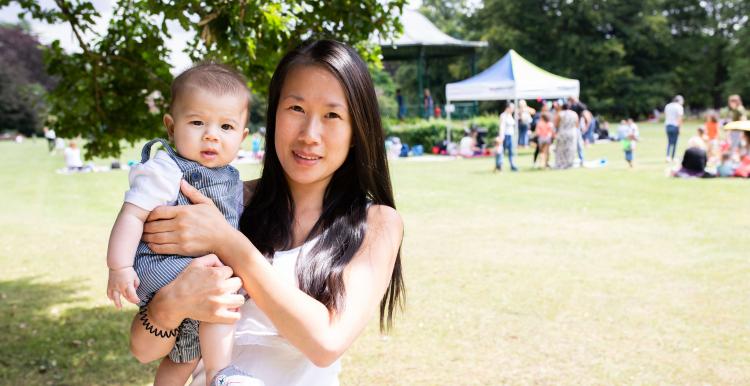 Mother holding her baby at an outdoor summer event