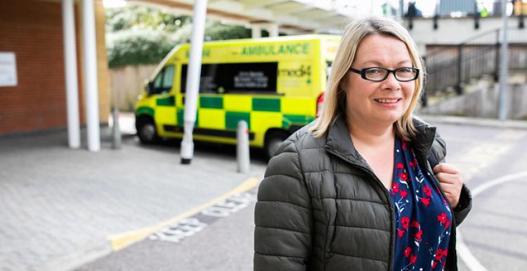 Woman smiling at the camera outside in a hospital car park