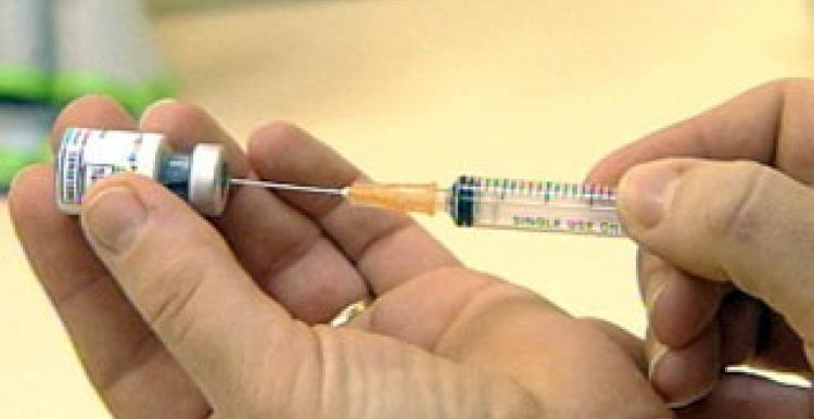 Hand injecting in vaccine bottle 