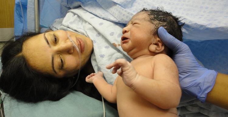 Picture of woman who's given birth looking at her newborn baby