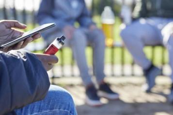 Young person on their phone whilst vaping