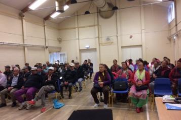 The Nepalese Association of Wiltshire sitting in a large hall