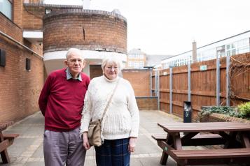 Elderley couple standing outside a building together