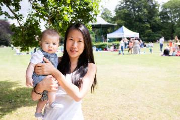 Mother holding her baby at an outdoor summer event