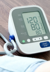 A blood pressure monitor showing a reading of 120 over 80.